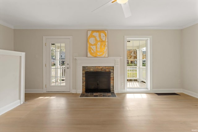 unfurnished living room featuring light hardwood / wood-style floors, a healthy amount of sunlight, and crown molding