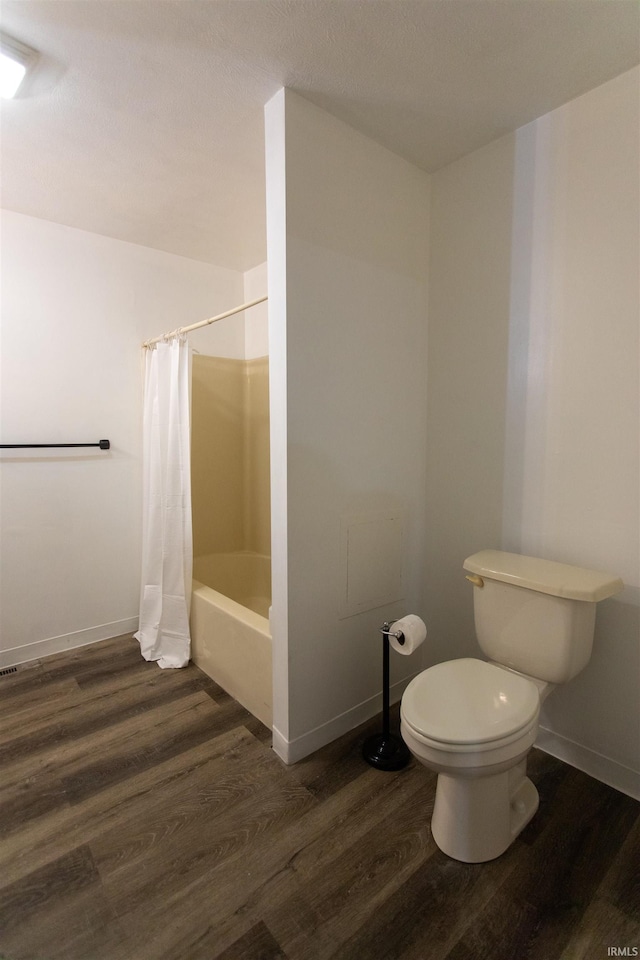 bathroom with wood-type flooring, toilet, and shower / tub combo