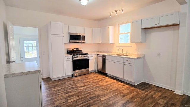 kitchen with plenty of natural light, appliances with stainless steel finishes, sink, and white cabinets