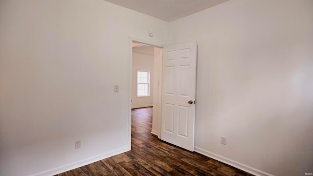 unfurnished room with dark hardwood / wood-style flooring