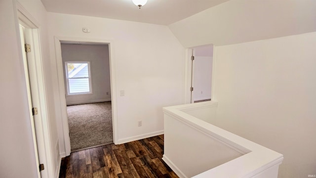 corridor with dark hardwood / wood-style flooring and lofted ceiling