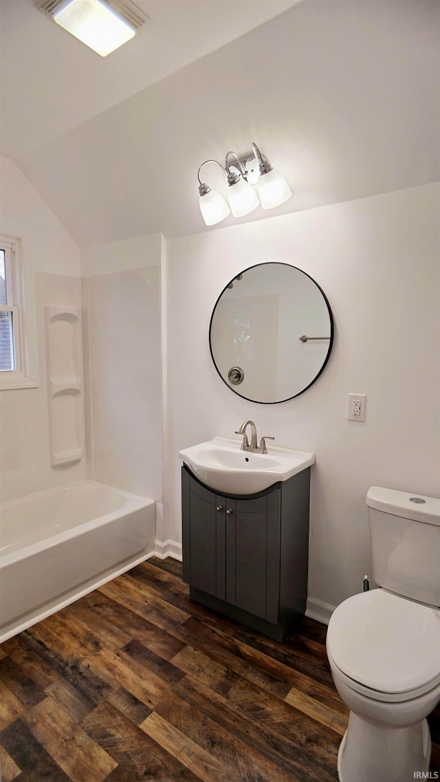 full bathroom with toilet, wood-type flooring, vanity, and vaulted ceiling