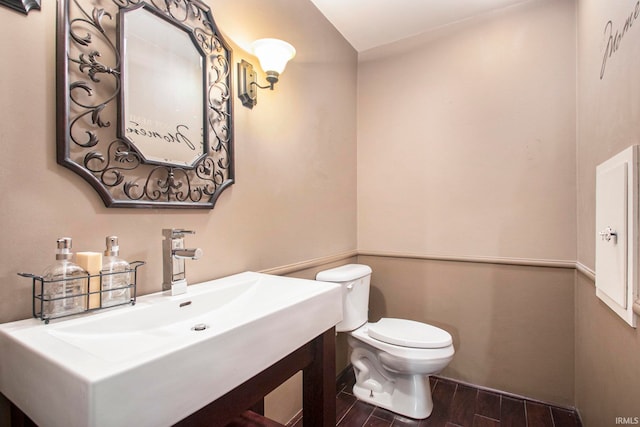 bathroom with hardwood / wood-style flooring, toilet, and sink