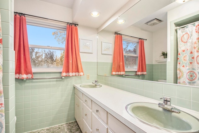 bathroom featuring tile walls, vanity, and toilet