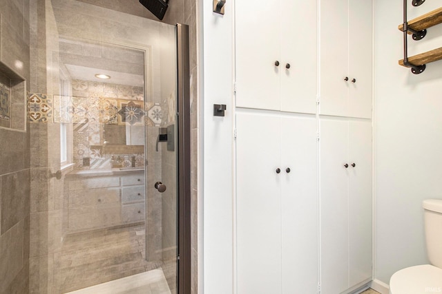 bathroom with toilet and a tile shower