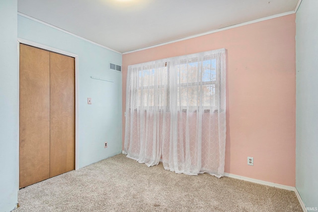 unfurnished bedroom with light carpet, a closet, and ornamental molding