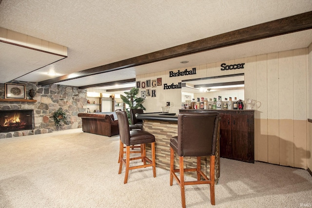 bar featuring beamed ceiling, a textured ceiling, and carpet