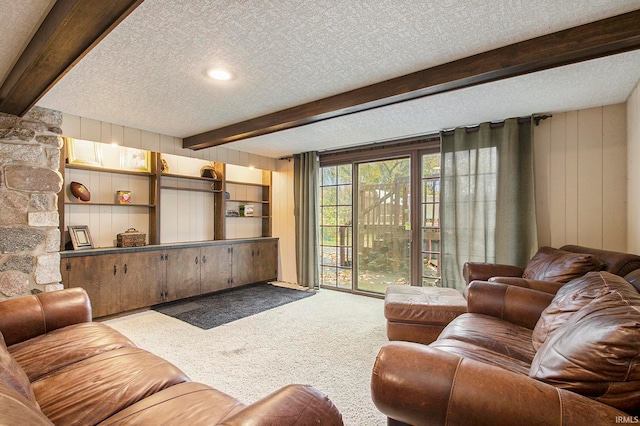 living room with wood walls, carpet, a textured ceiling, and beam ceiling