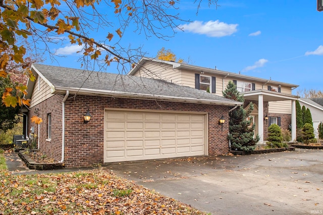 view of front of house featuring a garage and central AC