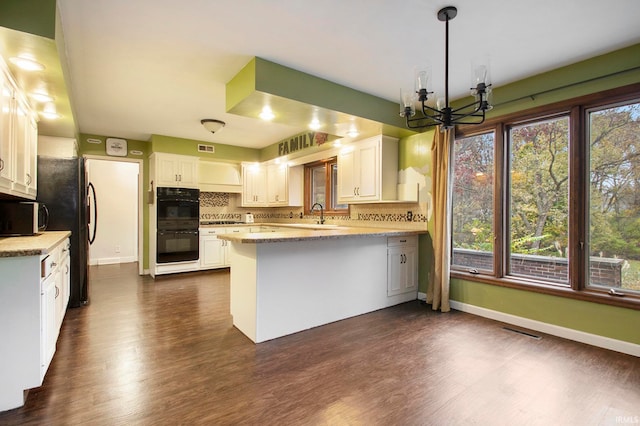 kitchen featuring dark hardwood / wood-style flooring, white cabinets, kitchen peninsula, black appliances, and tasteful backsplash