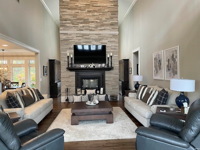 living room with a high ceiling, dark wood-type flooring, and crown molding