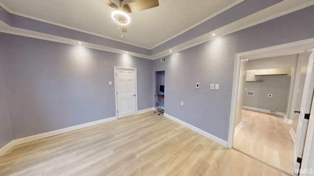 spare room with light wood-type flooring, ceiling fan, and crown molding