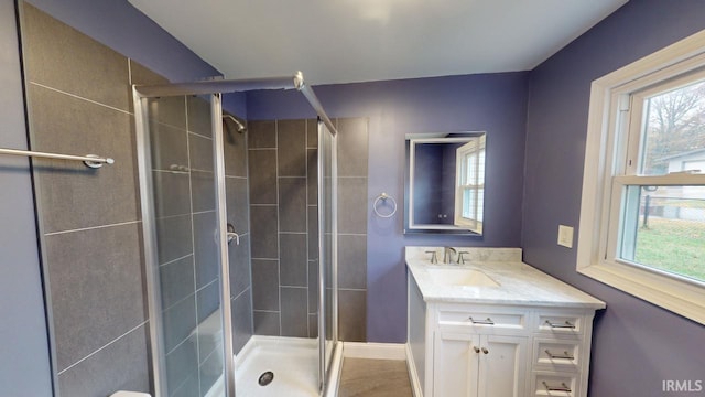 bathroom with vanity, a healthy amount of sunlight, and an enclosed shower