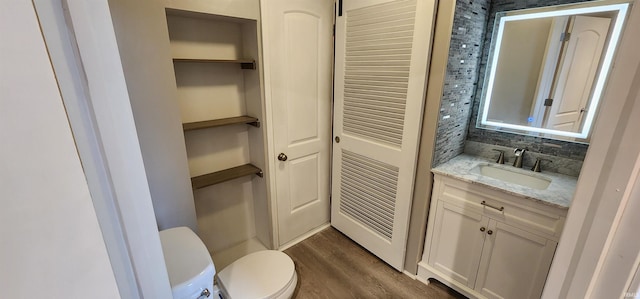 bathroom featuring wood-type flooring, vanity, and toilet