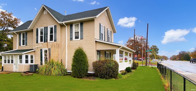 view of side of home featuring a lawn and central AC