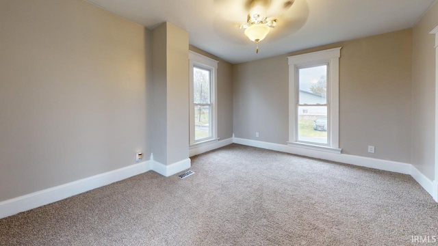 carpeted spare room featuring a healthy amount of sunlight