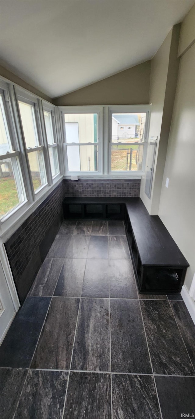 unfurnished sunroom featuring plenty of natural light and lofted ceiling