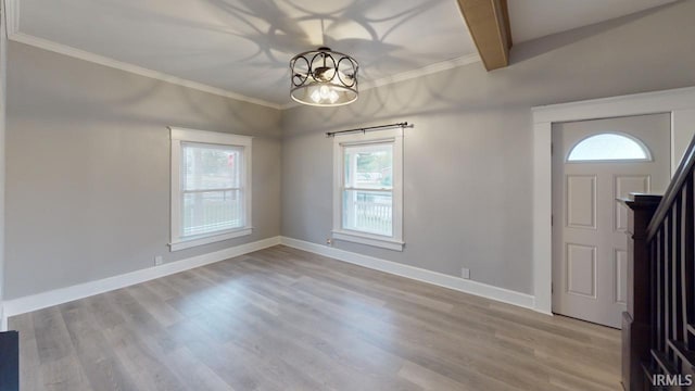 entryway with light wood-type flooring, plenty of natural light, and beam ceiling