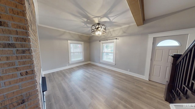 foyer entrance with light wood-type flooring, a wealth of natural light, and beam ceiling