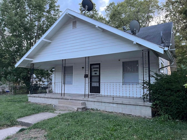 bungalow-style house featuring a front yard and covered porch