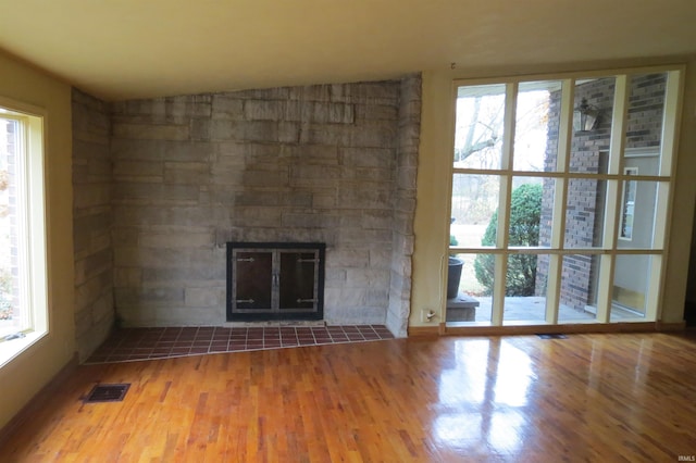 unfurnished living room with wood-type flooring, vaulted ceiling, and a fireplace