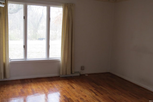 unfurnished room with hardwood / wood-style flooring and plenty of natural light