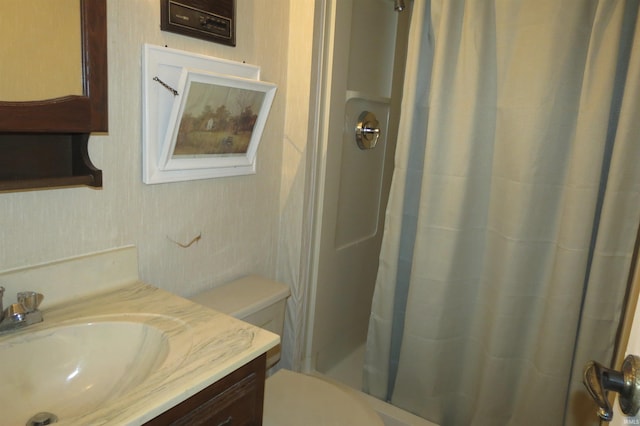 bathroom featuring curtained shower, vanity, and toilet