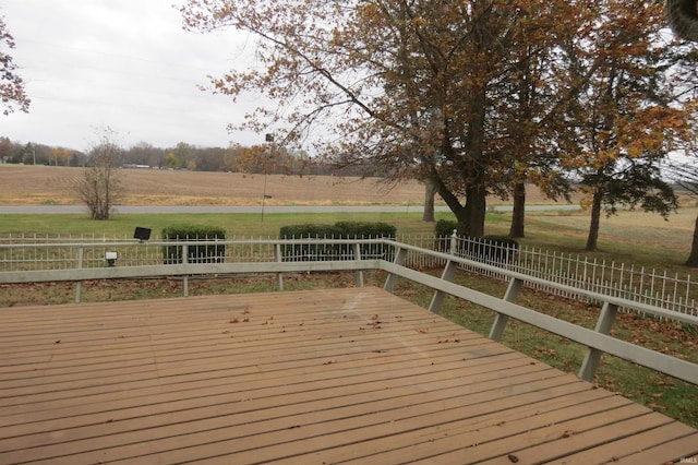 deck with a rural view and a lawn