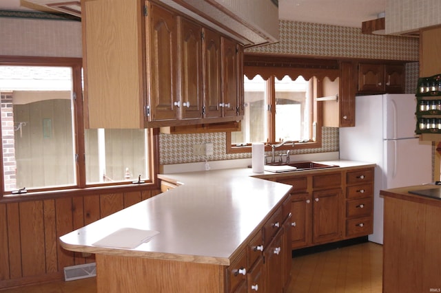 kitchen with light hardwood / wood-style flooring, sink, and backsplash