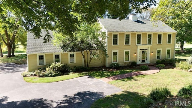 colonial inspired home with a front yard and french doors