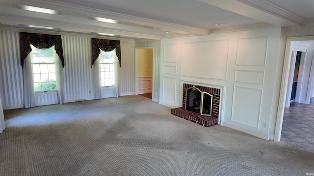 unfurnished living room with beam ceiling, light carpet, a brick fireplace, and crown molding