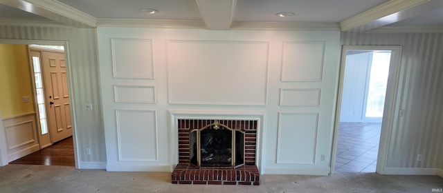 unfurnished living room with beam ceiling, light colored carpet, a fireplace, and crown molding