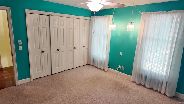 unfurnished bedroom featuring a closet, carpet, and ceiling fan