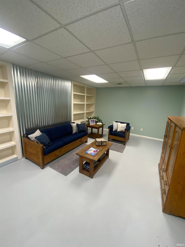 living room with built in features and a paneled ceiling