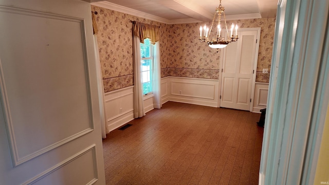 unfurnished dining area featuring ornamental molding, hardwood / wood-style flooring, and a notable chandelier