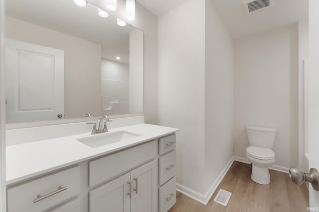 bathroom featuring vanity, hardwood / wood-style flooring, and toilet