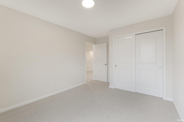 unfurnished bedroom with a closet and light carpet