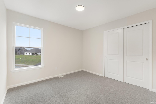 unfurnished bedroom featuring carpet flooring and a closet