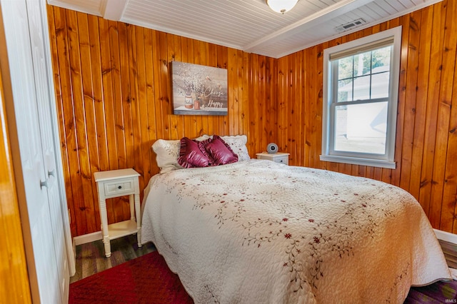 bedroom featuring wood walls, beamed ceiling, and wood-type flooring