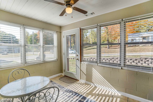 sunroom featuring ceiling fan and plenty of natural light