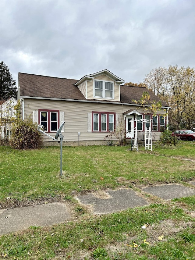 view of front of property featuring a front lawn and a shingled roof
