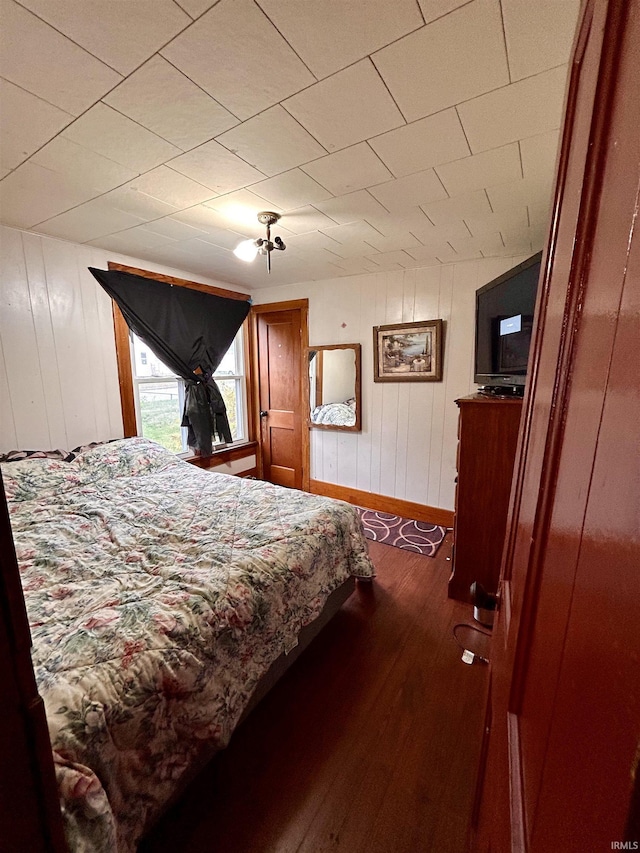 bedroom with dark wood finished floors and baseboards