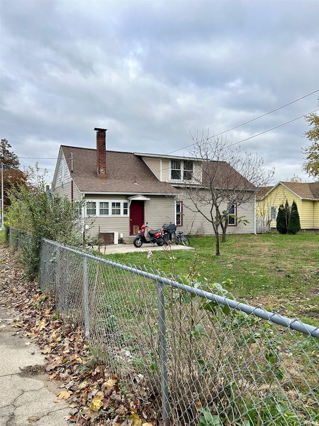 back of property featuring a chimney and roof with shingles