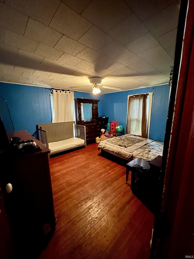 bedroom with wood-type flooring and a ceiling fan