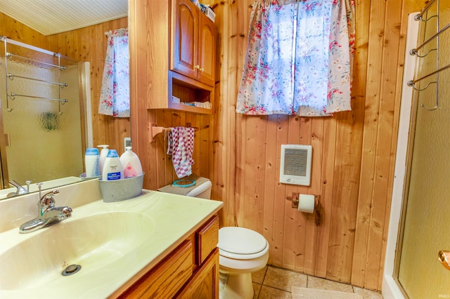 bathroom with a shower with door, tile patterned flooring, wood walls, heating unit, and vanity