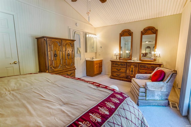 carpeted bedroom featuring lofted ceiling, sink, and ensuite bathroom