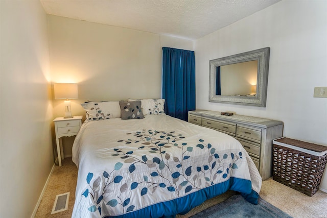 bedroom featuring light colored carpet and a textured ceiling