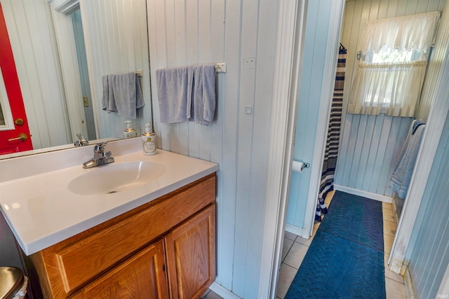 bathroom featuring vanity, tile patterned flooring, and wooden walls