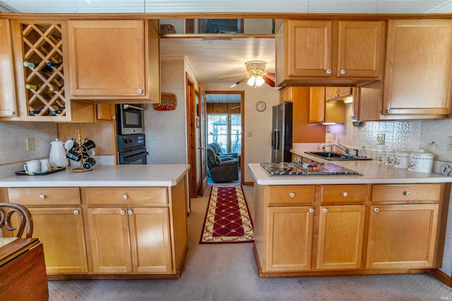 kitchen featuring backsplash, appliances with stainless steel finishes, light carpet, sink, and ceiling fan