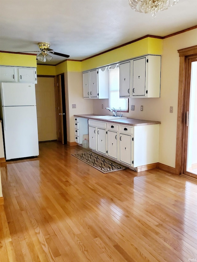 kitchen featuring light hardwood / wood-style floors, white cabinetry, sink, ceiling fan, and white fridge